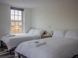 Minimalist twin bedroom with white bedding and a large window providing natural light